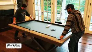 Two men moving pool table