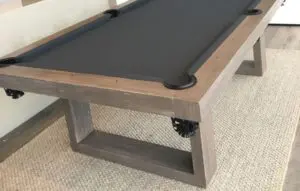 Close-up of a craftsman-style pool table frame and gray cloth