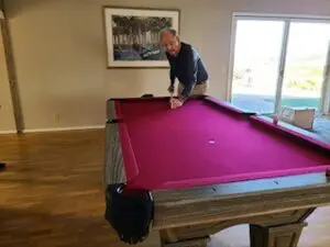 Man playing on a purple rug pool table